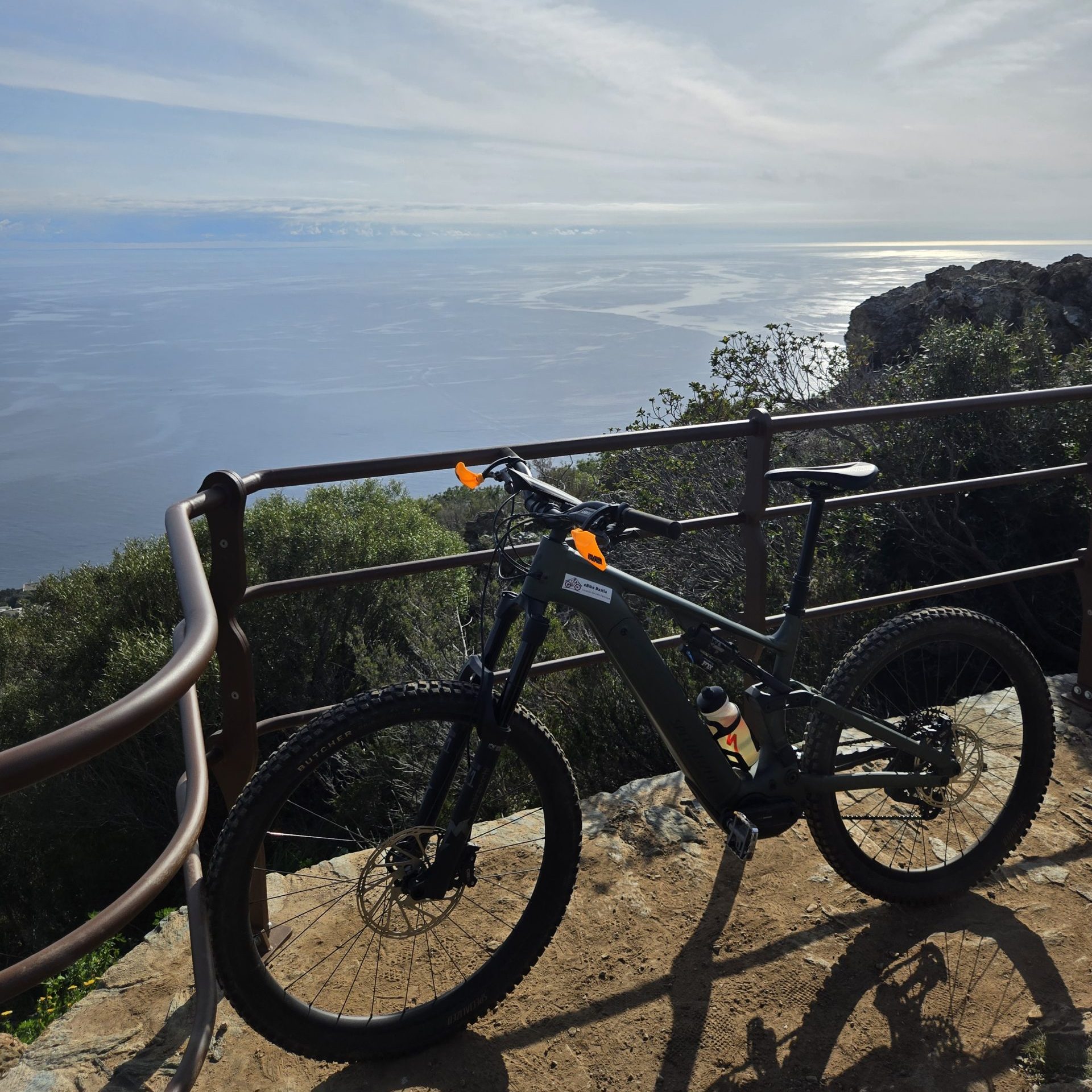 VTT garé sur un belvédère avec vue panoramique sur la mer en Corse